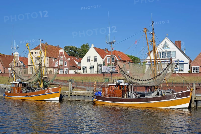 Crab cutter in the harbour in front of historic buildings, blue sky, Greetsiel, North Sea, Lower Saxony, Germany
