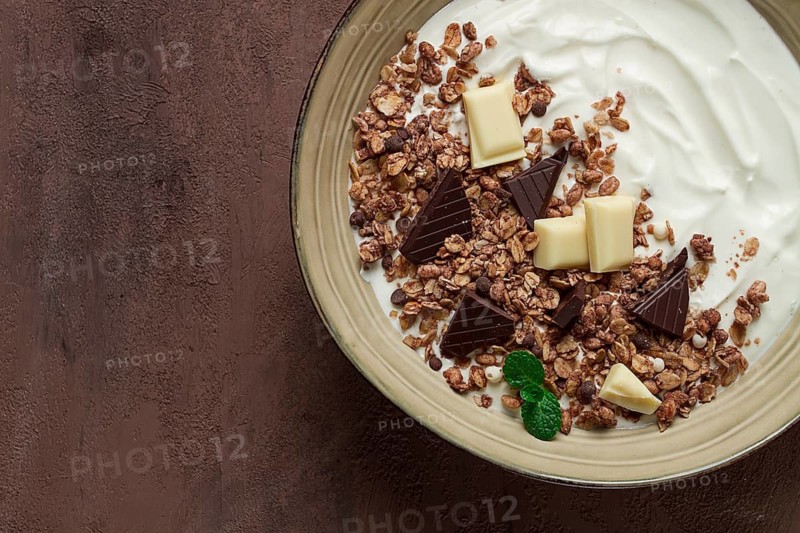 Yogurt with chocolate muesli, breakfast, close-up, fork on top, no people