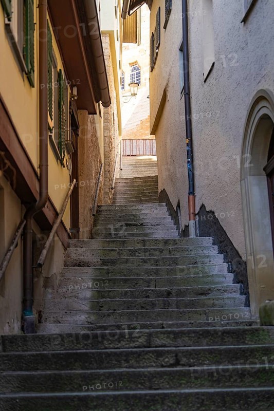 A steep staircase in a narrow old town alley under a blue sky, Schwäbisch Hall, Germany