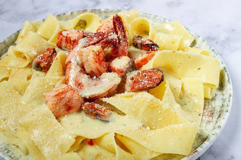 Papardelle pasta in creamy sauce with seafood, homemade, no people