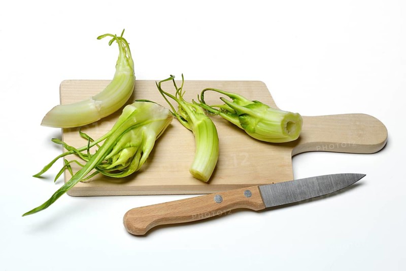 Puntarelle on wooden board with knife, asparagus chicory