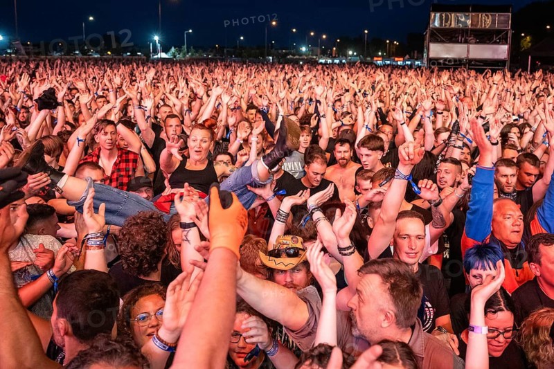 JAROCIN, POLAND - JULY 18, 2025: Jarocin Festival 2025 with rock music. Crowd surfing woman on the hands of fans