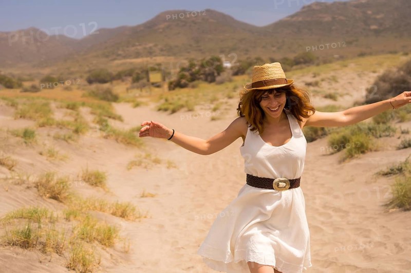Playful woman running along a sandy path in a national park in Cabo de Gata, Spain