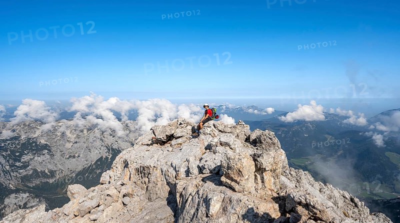 Mountaineer resting on a rock with mountain panorama, mountain tour to the summit of the Hochkalter, Hochkalter crossing, Berchtesgaden Alps, Bavaria, Germany