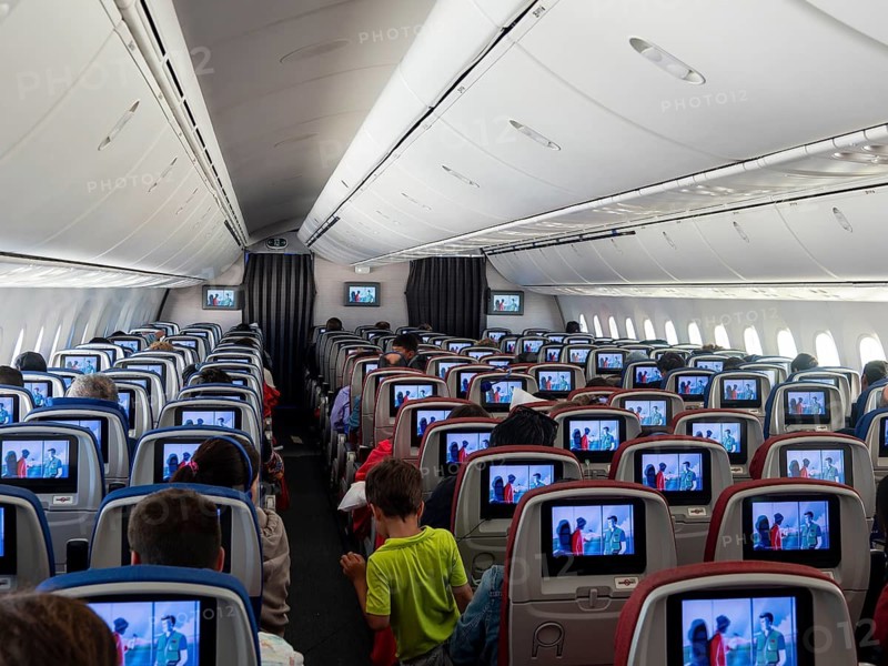 Aircraft interior, cabin with rows of seats and screens, Dreamliner Boeing 787