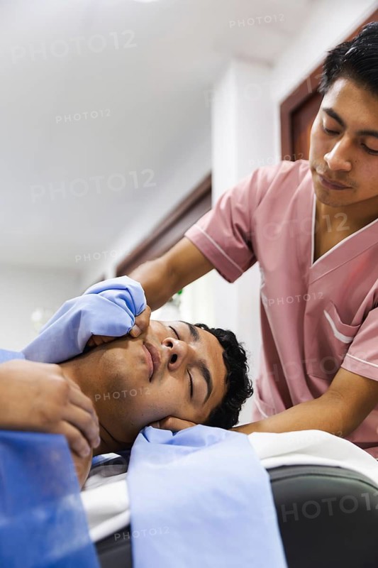 A therapist provides a soothing massage to a patient in an Ecuadorian physiotherapy clinic. The environment is calm, promoting healing and relaxation in a professional setting
