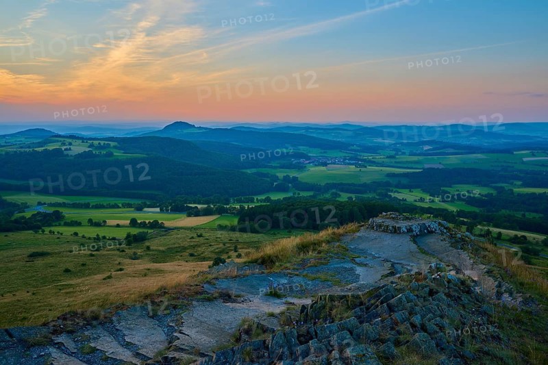 View over a hilly landscape at sunset with expansive sky and meadows, Abtsroder Kuppe, Abtsroda, Wasserkuppe, Rhön, Hesse, Germany