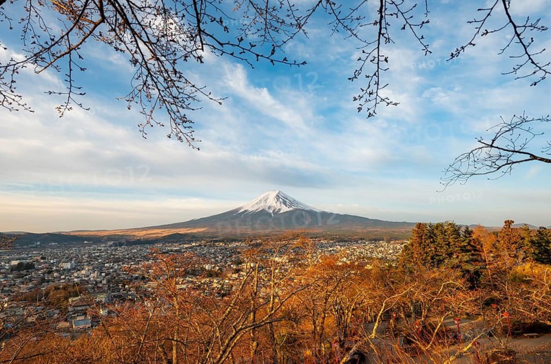 View of Mount Fuji volcano over Fujiyoshida City in morning light, at sunrise, Arakurayama Sengen Park, Yamanashi Prefecture, Japan