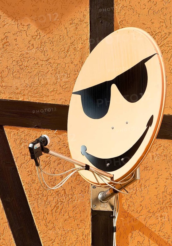 Satellite dish with smiley on a house wall in Langenstein, Halberstadt, Saxony-Anhalt, Germany