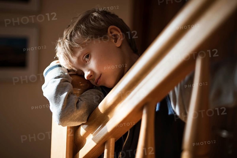Bored boy by the railing on the stairs