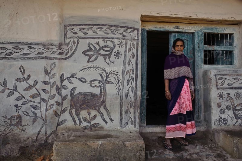 Low caste woman standing outside her house, Khovar art (Hazaribagh, Jharkhand, India) . The Sohraï and Khovar art are art forms practised by the rural low caste and tribal women in the Hazaribagh district. Every october-november, they paint their house mud walls to welcome the harvest and celebrate the cattle. These paintings depict animals and plants of the surroundings in a simple way
