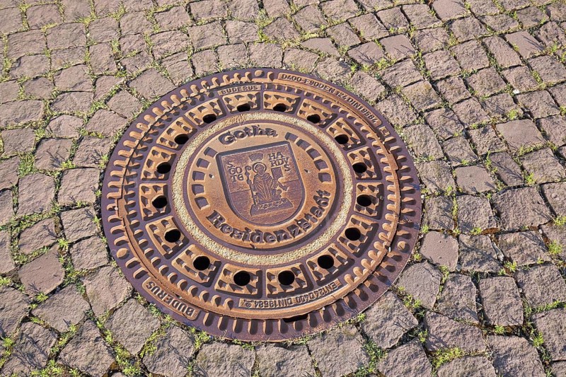 Round manhole cover with city coat of arms and inscription Residenzstadt, cobblestones, ground, main market, Gotha, Thuringia, Germany