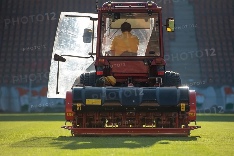 Man in tractor aerating a soccer field