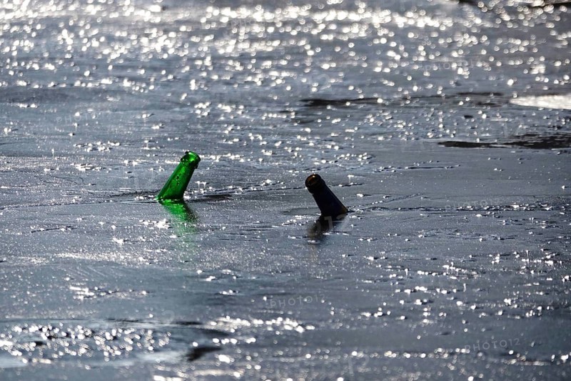 Discarded glass bottles in a frozen lake, winter, Germany