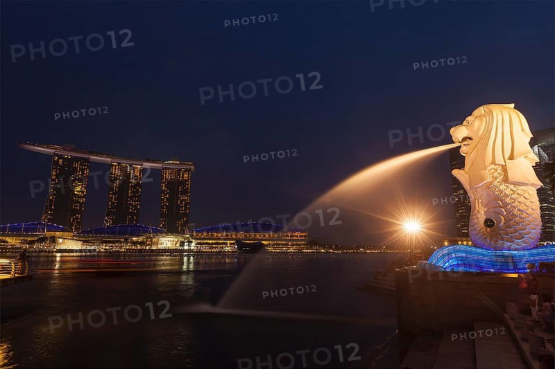 SINGAPORE, JANUARY 1, 2014: Night view of Singapore Merlion at Marina Bay and Marina Bay Sand complex. Merlion is a well-known tourist icon, mascot and national personification of Singapore
