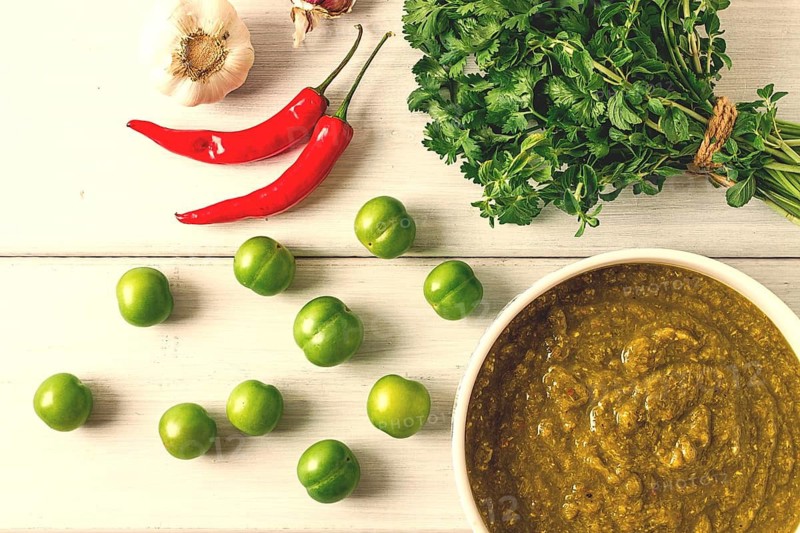 Tkemali sauce, traditional Georgian cuisine, green cherry plum, with ingredients for sauce, cilantro, mint, hot pepper, garlic, on a white wooden table, close-up, rustic, food background, no people, selective focus, sauce, green sauce, tkemali, georgian cuisine, homemade