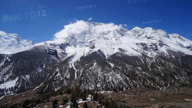 Large snowy mountains under clear skies in the natural Himalayan landscape, trekking at Annapurna Circuit, Manang, Nepal