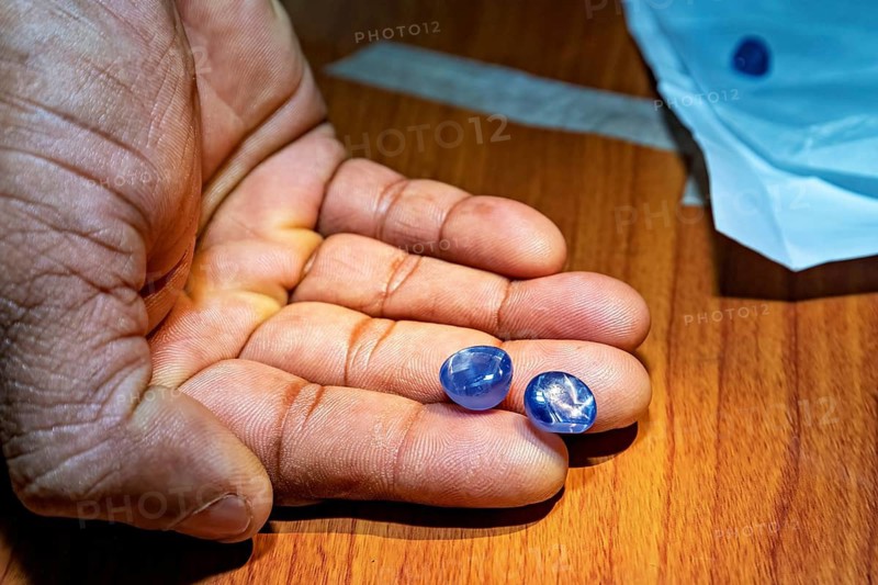 Two blue gemstones lying on a wooden background, the sapphire emeralds and precious stones from the city of Ratnapura in Sri Lanka