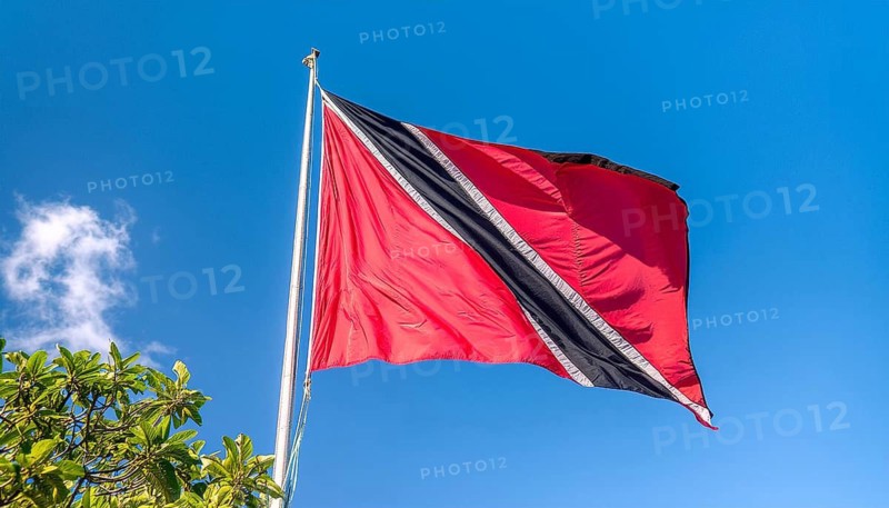 The flag of Tobago, Caribbean, flutters in the wind, isolated against a blue sky