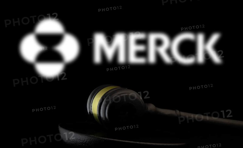 Court gavel in front of the Merck logo. Merck & Co Inc is an American multinational pharmaceutical company.