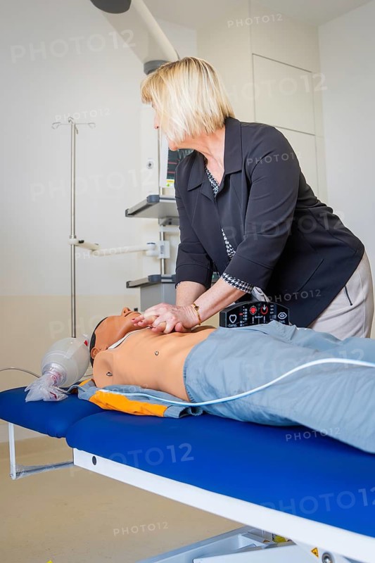Woman practicing resuscitation on a doll in a medical training room, opening hospital, Calw, Germany