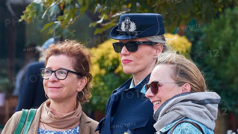 Two woman pose with a uniformed police officer for a photo outdoors, Visit of Federal President Frank-Walter Steinmeier in Kandanos on 31 October 2024, Federal President, Frank-Walter Steinmeier, memorial, war crimes, Nazis, Wehrmacht crimes, World War II, Kandanos, southwest Crete, Crete, Greek islands, Greece