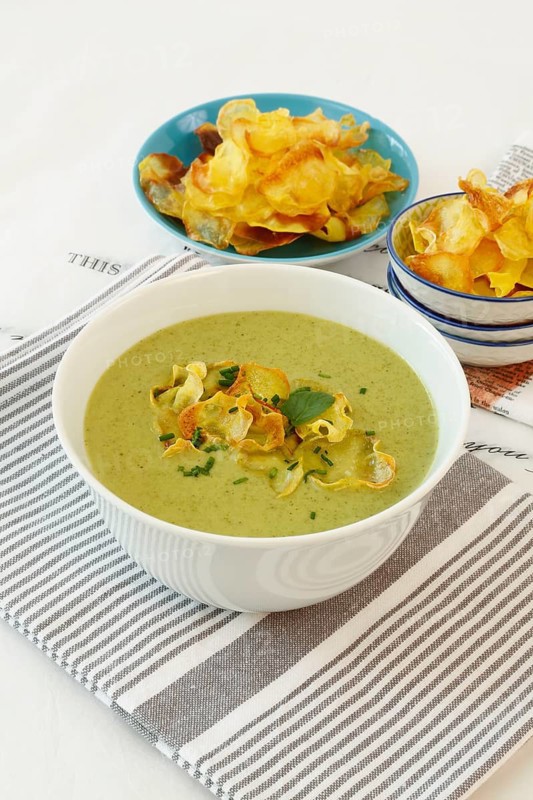 Swabian cuisine, cress soup with crisps, cress, plate with green cream soup, soup bowl, garnished with herbs, hearty soup, bowl with crisps, tea towel, writing, letters, vegetarian, healthy, salty, cooking, typical Swabian reinterpreted, traditional cuisine, food photography, studio, tablecloth, Germany