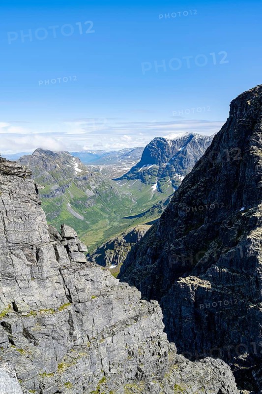 View between rocks at the summit of Innerdalstårnet on Innerdalen high valley, Trollheimen Mountain Area, Sunndal, Møre og Romsda, Vestlandet, Norway
