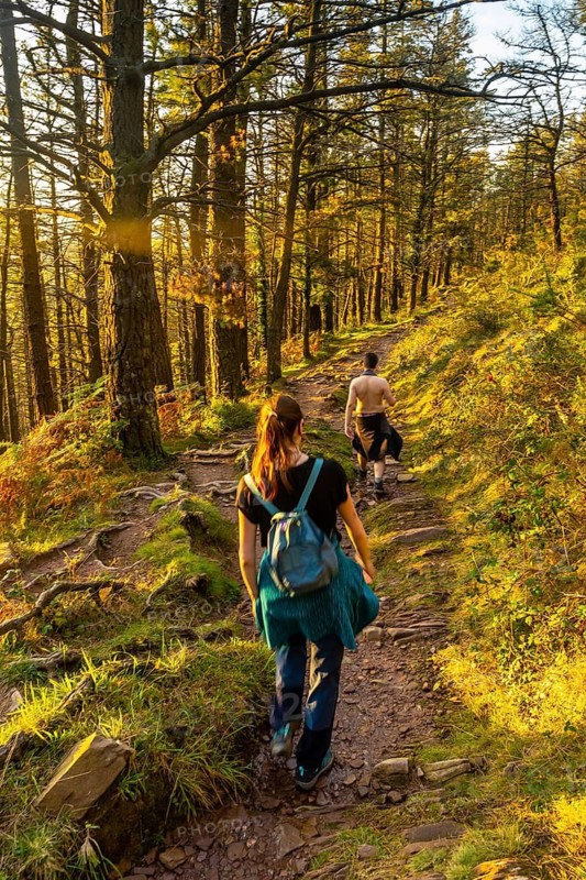 A couple on the trail at sunset of Mount Adarra in the town of Urnieta near San Sebastian, Gipuzkoa. Basque Country