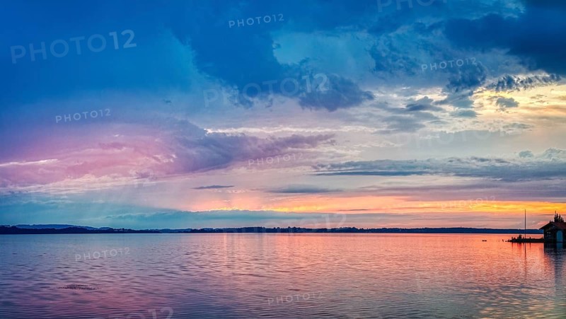 A calm lake at sunset with blue and pink colours in the sky, Übersee, Chiemsee