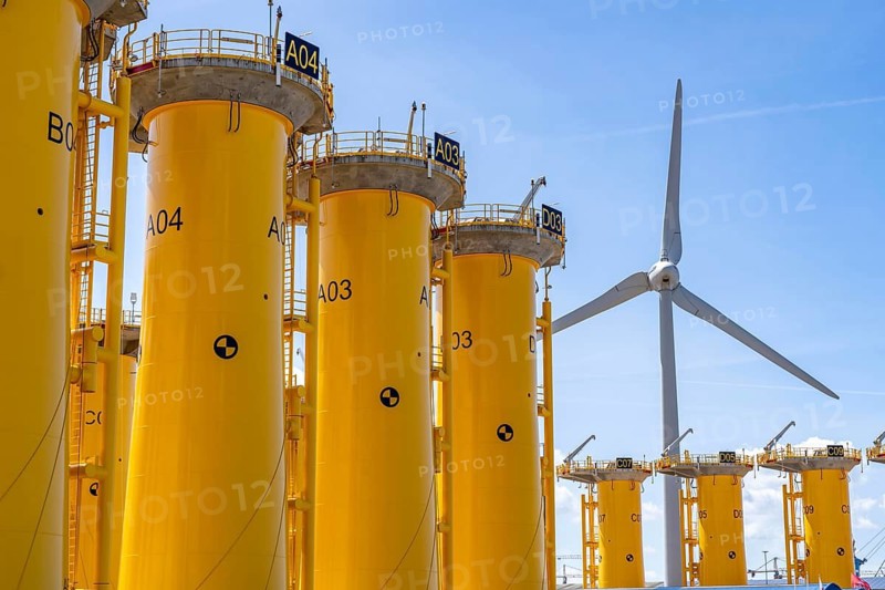 Transhipment centre for offshore wind turbines, which are transported here by the manufacturer and then shipped by special ships to the construction sites of the wind farms in the North Sea, here, yellow, so-called Transition Pieces Jackets, which are mounted on the monopile foundations driven into the seabed, on which the actual wind turbine is then mounted, in the port area of Vlissingen-Oost, Netherlands