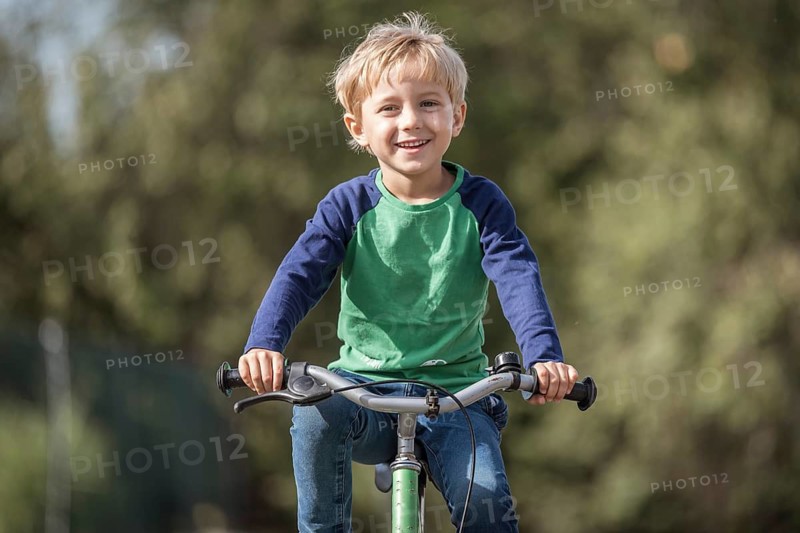 Smiling little boy ride on a bicycle