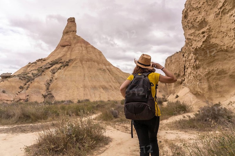 Rear view of a sportive woman strolling along a arid path in a natural reserve