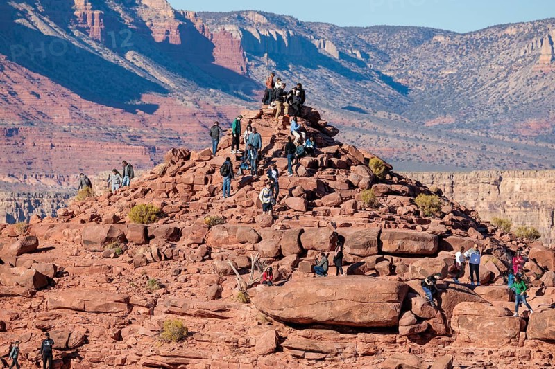 Visitors climb on rock formation rising above the canyon at Guano Point in Grand Canyon West near Peach Springs, Arizona