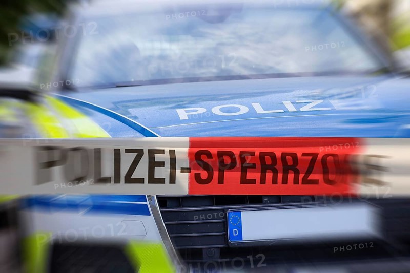 (Photomontage) Symbolic image of a police operation: police cordon in front of an emergency vehicle