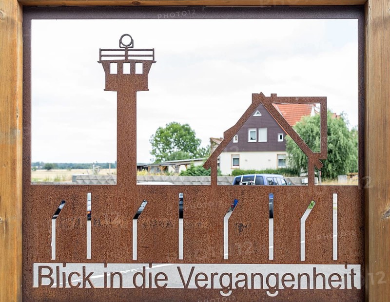 View into the past with shop window with border fence and border tower in front of a still existing house at the former inner-German border, Stapelburg, Nordharz, Saxony-Anhalt, Germany