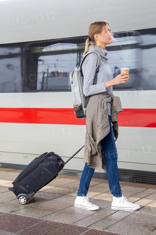 Young woman on the railway track while a train arrives