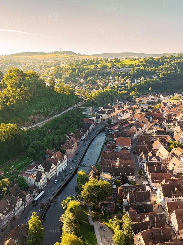 Small town view with river and bridge, surrounded by hills and forests on a sunny day, Calw, Black Forest, Germany