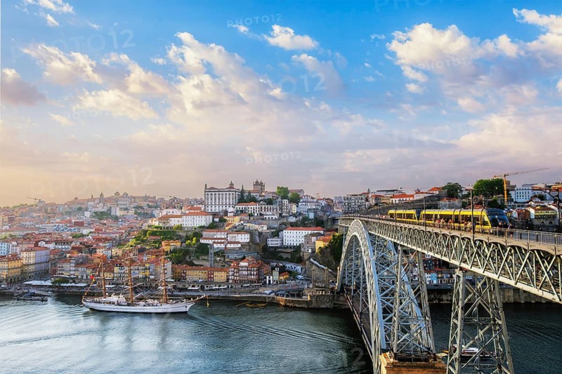 View of Porto city and Douro river and Dom Luis bridge I with tram from famous tourist viewpoint Miradouro do Jardim do Morro on sunset. Porto, Vila Nova de Gaia, Portugal