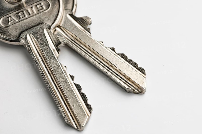 Close-up of two keys of a cylinder lock, white background