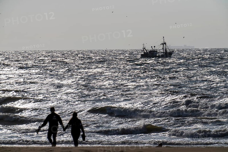 Strollers on the beach of Scheveningen, shrimp cutter, Netherlands