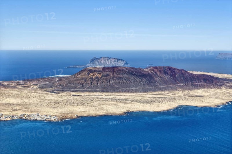 Dramatic volcanic island, La Graciosa, with barren surface, surrounded by deep blue ocean and endless sky, Lanzarote, Canary Islands, Spain