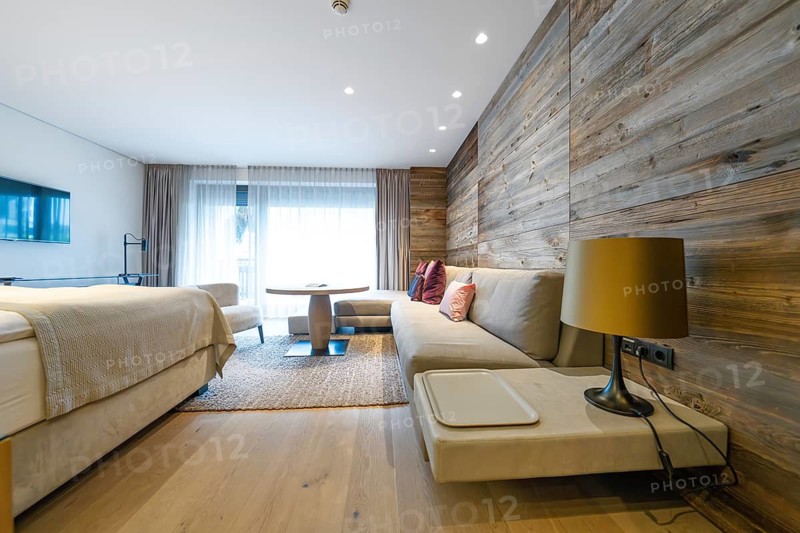 Modern living area with sofa, wood panelling and large window front, Mayrhofen, Zillertal, Austria