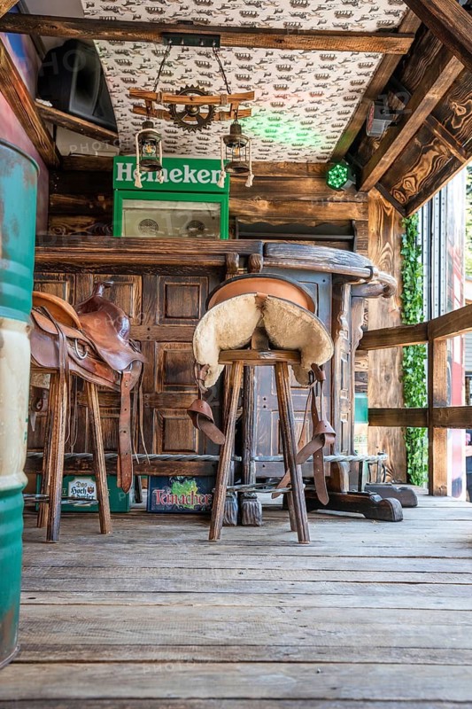 Wooden bar with bar stools decorated with saddles