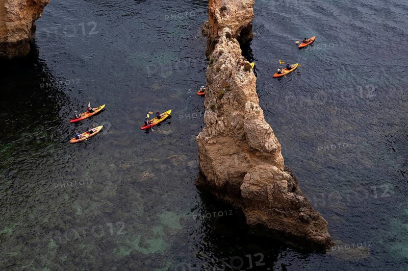 Kayaker, kayaks, kayaking, guided tour through grottos, rocks in the sea, Ponta da Piedade, Lagos, cliffs, Atlantic Ocean, Algarve, Portugal