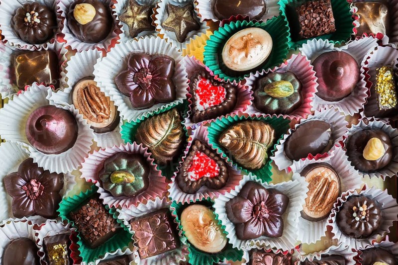 Top view and close-up of hand made mixed flavor fancy fine delicious chocolates in opened chocolate box, Studio Composition, Quebec, Canada