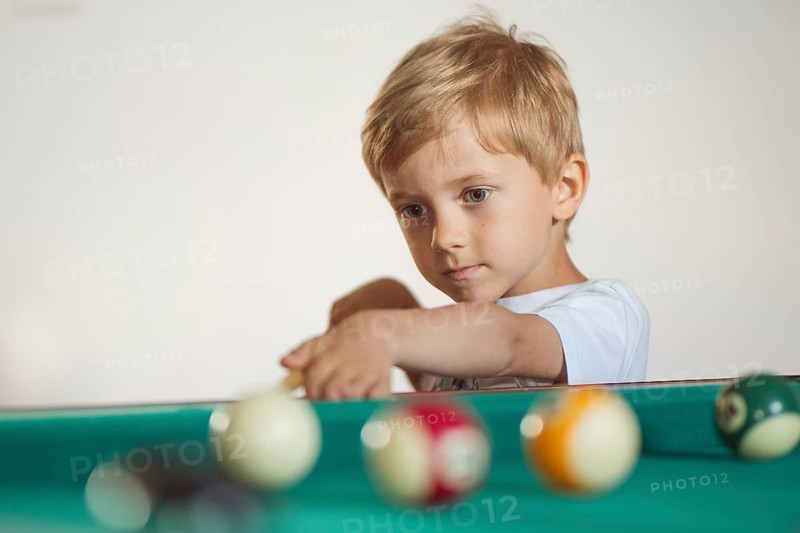 5-6 years old boy playing billiard