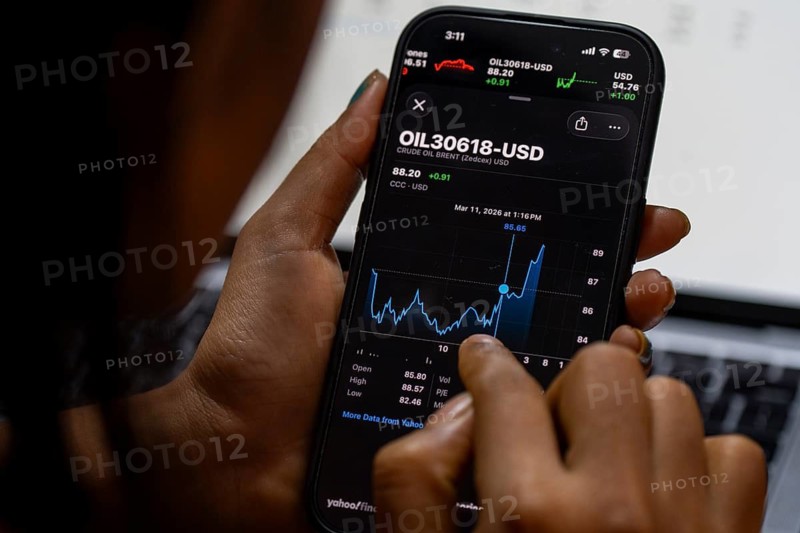 In this photo illustration, a person looks at a smartphone displaying Brent crude oil prices in USD, in Guwahati, India, on March 11, 2026. Oil prices reversed course from recent highs, slipping to around 90 USD a barrel after remarks by U.S. President Donald Trump on the Iran conflict. Markets remain unsettled as traders monitor the evolving geopolitical situation