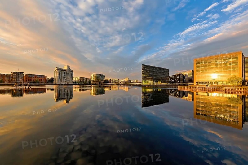 Breite Wasserfläche spiegelt moderne Architektur und Himmel am frühen Morgen, Kopenhagen, Dänemark