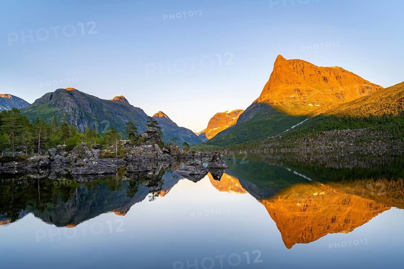 Picturesque mountain landscape with Innerdalstårnet peak in the Innerdalen high valley, mountain peaks reflected in Lake Innerdalsvatna, in the evening light at sunset, Trollheimen Mountain Area, Sunndal, Møre og Romsdal, Norway
